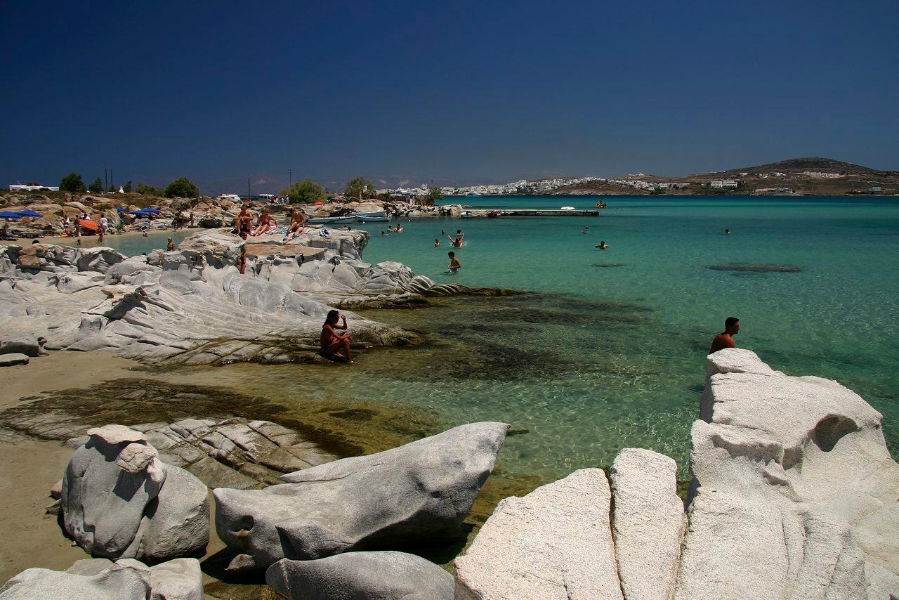 άνθρωπου απολαμβάνουν το μπάνιο τους στα τιρκουάζ νερά της παραλίας Φάραγγας παραλιεσ παρου